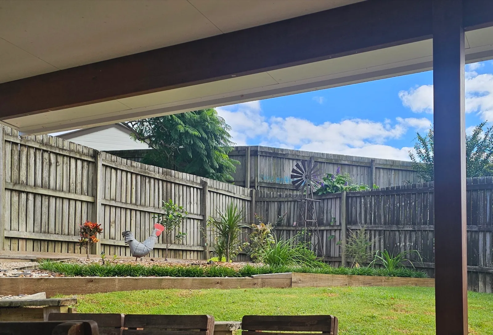 Backyard garden with timber raised beds and windmill feature